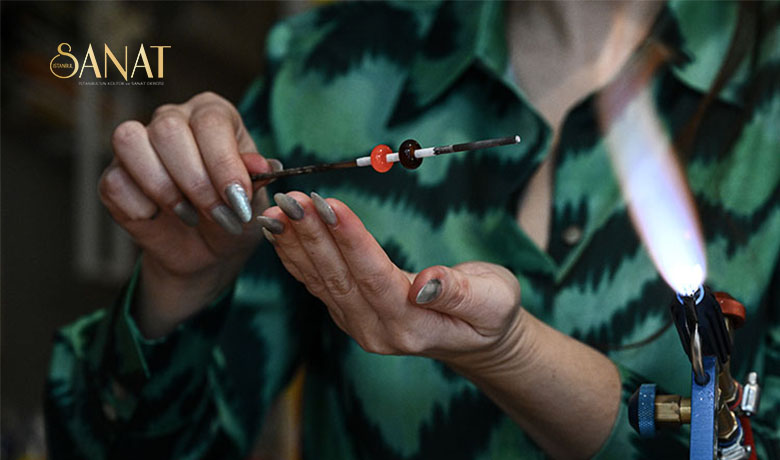 Cam sanatçısı Nermin Taş, evindeki atölyede atık camlardan yaptığı takılarla